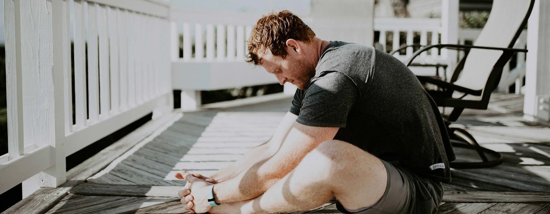 man stretching on a deck